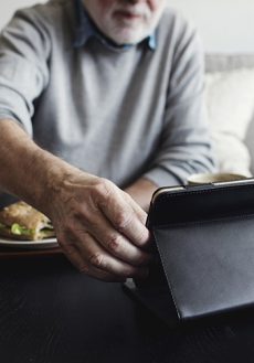 Äldre man som använder en surfplatta