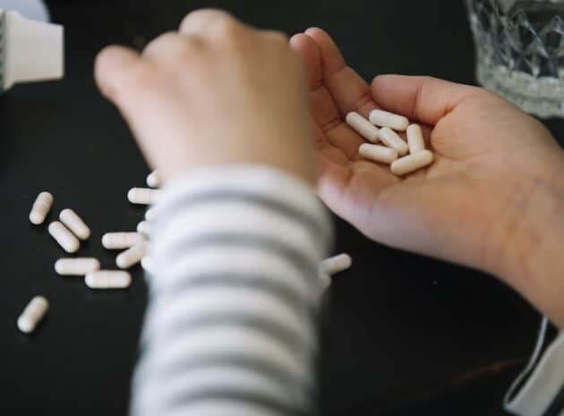 Händer som håller i medicin